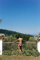 Aura - Bikini in Plum / Pink Polka Dot — full back view overlooking the coast